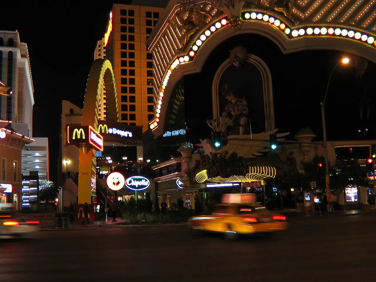 As we can see in the image there are buildings, traffic signals, street lamp, statue, banners,...