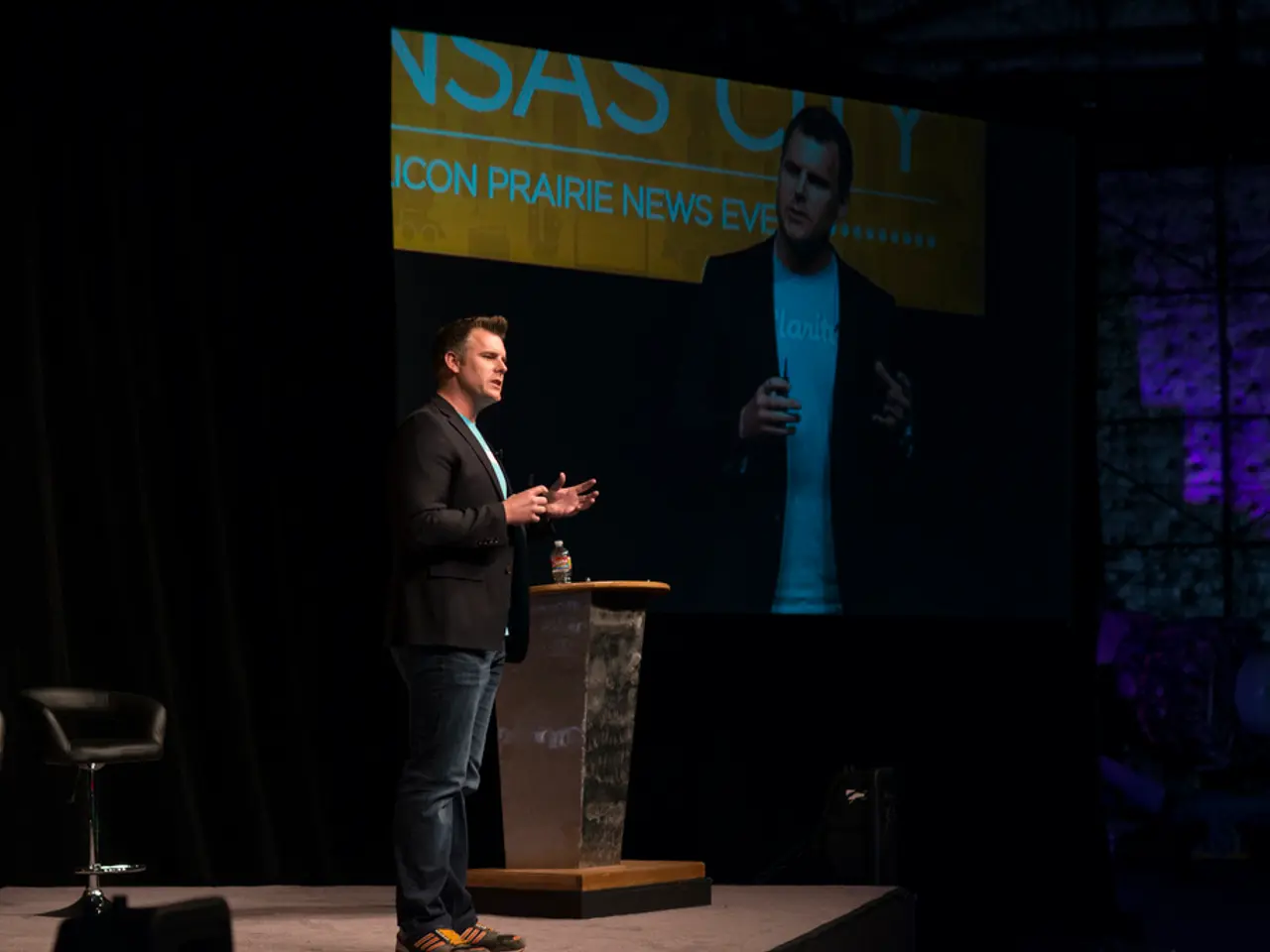 It is a seminar , a person wearing black color shirt is talking something, beside him there is a...