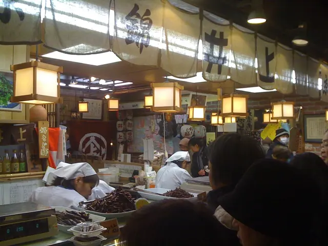 In this image there are a few people working in a restaurant, in front of them on the counter there...