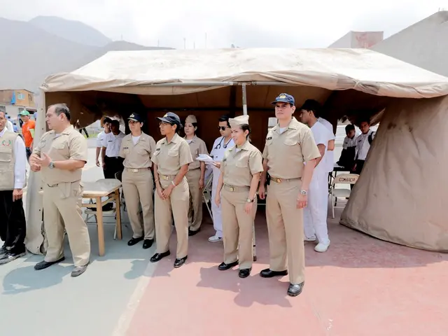 In this picture there are some policemen and women standing in the front. Behind there is a tent...